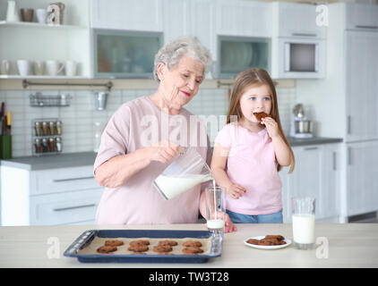 Carino bambina e la nonna con i cookie su cucina Foto Stock