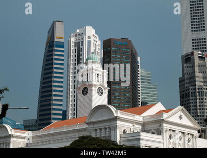Un paesaggio urbano vista della torre dell'orologio di Victoria Theatre e dalla sala da concerto con i grattacieli di Singapore il quartiere finanziario dietro Foto Stock