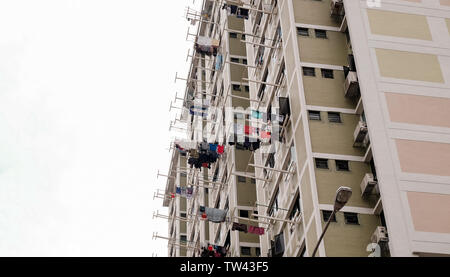 Zona residenziale di alto-aumento alloggio con servizio lavanderia lavaggio dei panni appesi al di fuori su rotaie fuori delle finestre in Singapore. Foto Stock