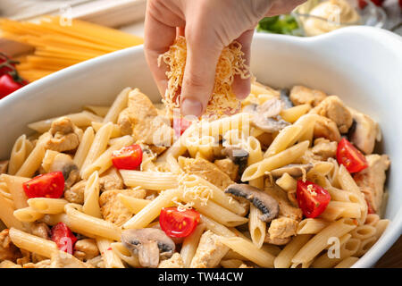 Mano di donna deliziosa cucina turchia tetrazzini in cucina Foto Stock