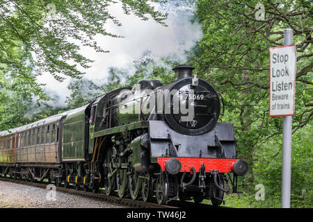 Close up isolato vintage UK treno a vapore parte anteriore si avvicina, passando attraverso rurali campagna estiva sul patrimonio della linea ferroviaria. Locomotiva vintage. Foto Stock