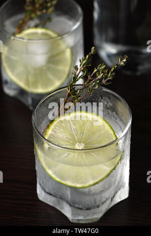 Gin Tonic con una fetta di limone e rametti di timo Foto Stock