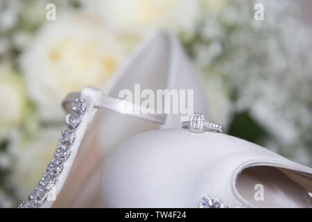 Brides anello di fidanzamento seduto sulla parte superiore del suo giorno di nozze scarpa, white satin diamante cassone nuziale, in attesa di essere indossato il giorno delle nozze. Foto Stock