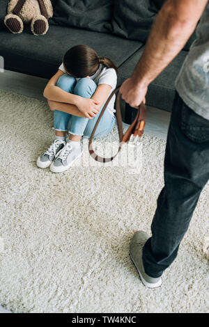 Vista aerea del padre con la cinghia e la figlia seduta sul pavimento Foto Stock