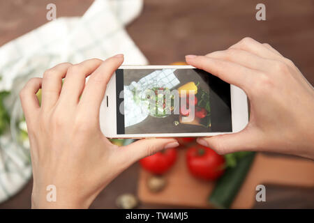 Mani femminili prendendo foto di alimenti con il telefono cellulare Foto Stock