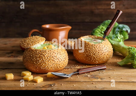 Broccoli zuppa di formaggio in focacce di pane sul tavolo di legno Foto Stock