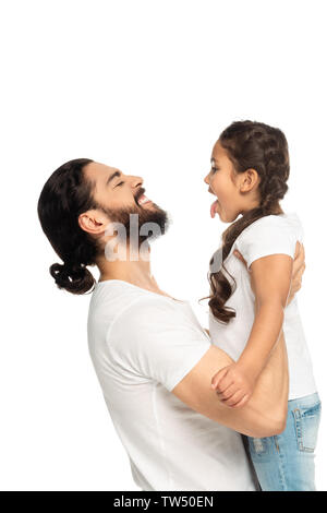 Happy latino padre sorridente tenendo in bracci figlia carino che mostra la linguetta isolata su bianco Foto Stock