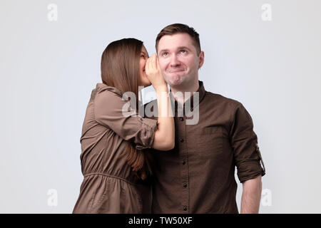 Giovane donna sussurro segreto per il suo fidanzato Foto Stock