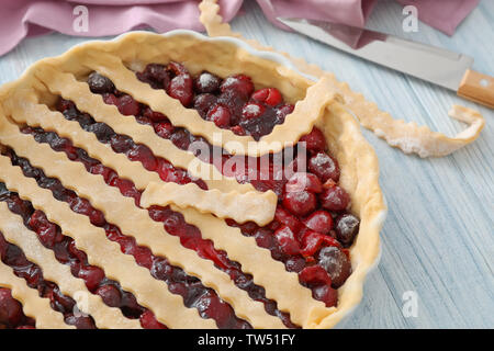 Teglia crudi con torta di ciliegie sul tavolo da cucina Foto Stock