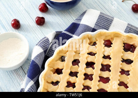 Teglia crudi con torta di ciliegie sul tavolo da cucina Foto Stock