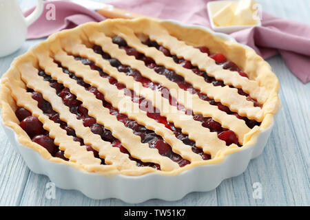 Teglia crudi con torta di ciliegie sul tavolo da cucina Foto Stock