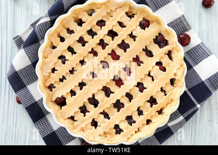 Teglia crudi con torta di ciliegie sul tavolo da cucina Foto Stock