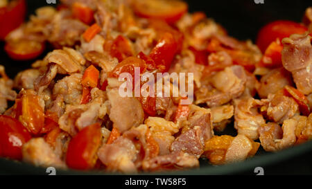 Pomodori pancetta cipolla carote in padella Foto Stock