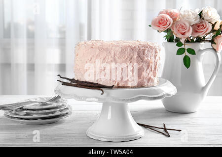 Composizione con vaniglia e Torta di rose bianche sul tavolo di legno Foto Stock