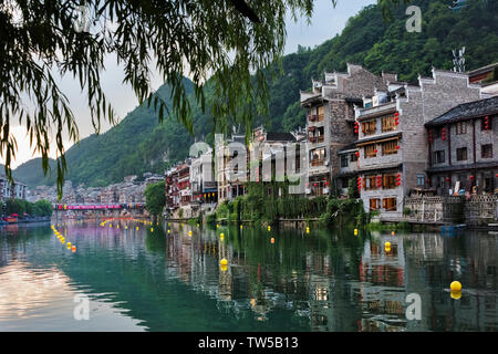 Case tradizionali lungo il fiume Wuyang con riflesso nell'acqua, Zhenyuan, Guizhou, Cina Foto Stock