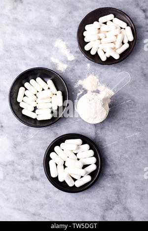 Scoop di proteina di siero di latte, idrolizzati di collagene di tipo I, L-prolina e L-lisina capsule. Supplementi per supportare la produzione di collagene. Foto Stock