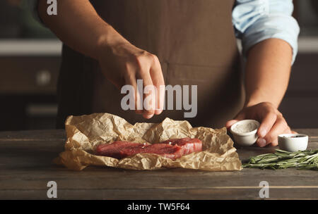 Lo Chef la cottura della carne sul tavolo Foto Stock