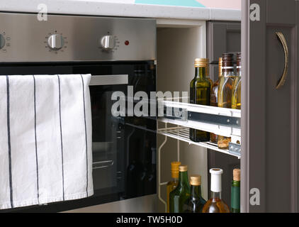 Bottiglie di olio e di vino vicino al forno in cucina Foto Stock