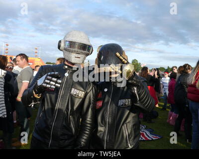 Newport, Isola di Wight. Il 16 giugno 2019. Isle of Wight Festival - Robot umani duo con il biker caschi in mostra il loro abbigliamento costumi nouveau. Foto Stock