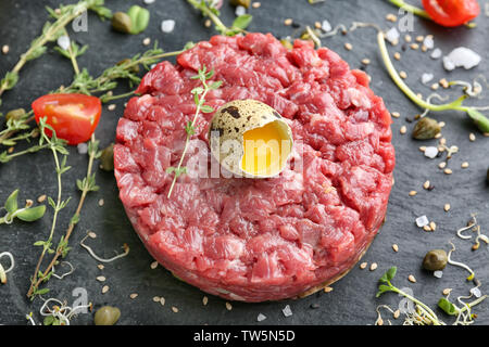 Deliziosa la tartare di manzo con tuorlo d'uovo sulla piastra di ardesia Foto Stock