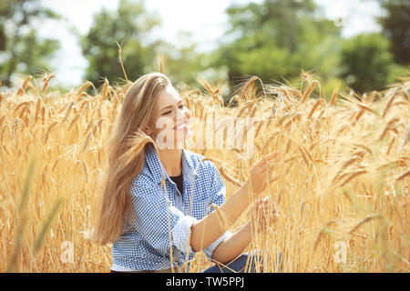 Donna di toccare il frumento spikelets nel campo Foto Stock