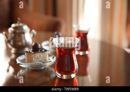 Tè turco in vetro tradizionale con dessert sulla tavola Foto Stock