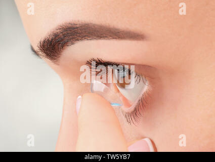 Giovane donna mettendo una lente a contatto, primo piano Foto Stock