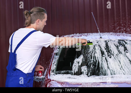 Uomo di pulizia del parabrezza per automobile con ventosa a lavaggio auto Foto Stock