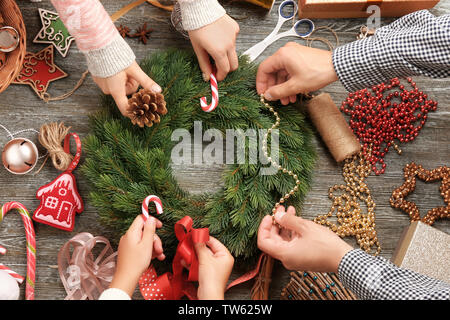 Famiglia decorazione di Natale corona su sfondo di legno Foto Stock