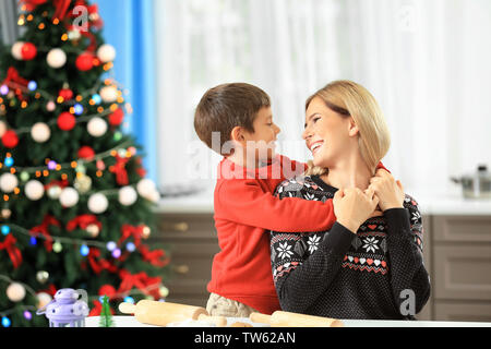 Giovane donna la preparazione di biscotti di Natale con il piccolo figlio in cucina Foto Stock