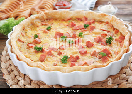 Deliziosa casseruola con salsicce in una teglia sul tavolo Foto Stock
