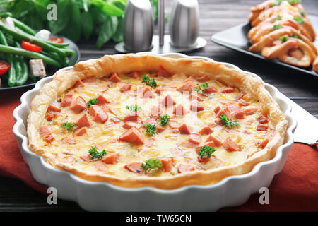 Deliziosa casseruola con salsicce in una teglia sul tavolo Foto Stock