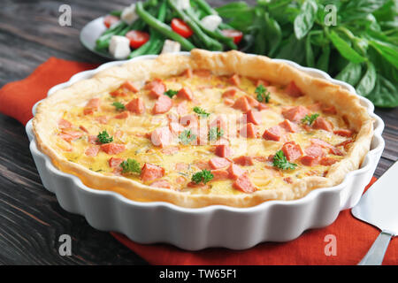 Deliziosa casseruola con salsicce in una teglia sul tavolo Foto Stock