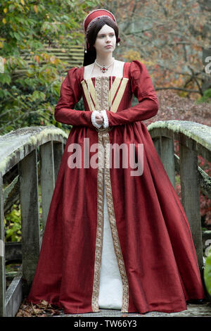 Tudor woman in red dress passeggiate nel giardino Foto Stock
