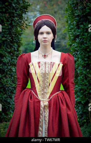 Tudor woman in red dress passeggiate nel giardino Foto Stock