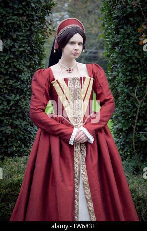 Tudor woman in red dress passeggiate nel giardino Foto Stock