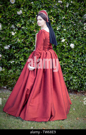 Tudor woman in red dress passeggiate nel giardino Foto Stock