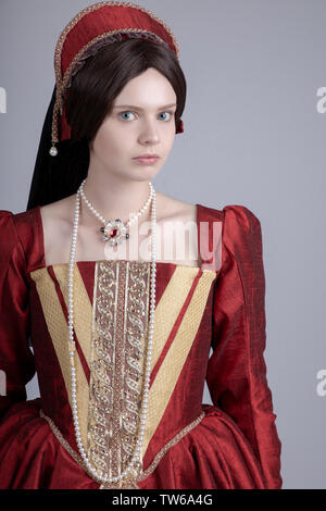 Tudor woman in red dress passeggiate nel giardino Foto Stock