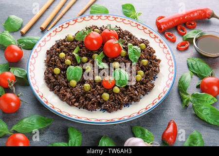 Composizione con piatto di deliziosa riso nero sul tavolo Foto Stock