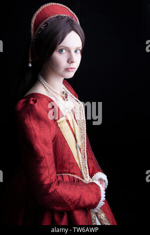 Tudor woman in red dress passeggiate nel giardino Foto Stock