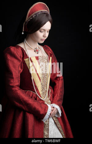 Tudor woman in red dress passeggiate nel giardino Foto Stock