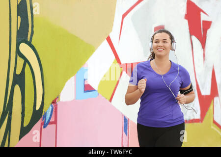 Il sovrappeso giovane donna fare jogging in strada. La perdita di peso concept Foto Stock