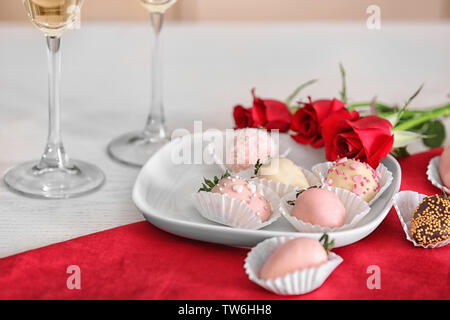 Piastra con gustose fragole vetrate sul tavolo Foto Stock