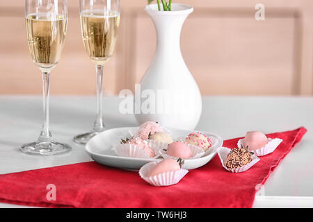 Piastra con gustose fragole smaltate e bicchieri di champagne sul tavolo Foto Stock