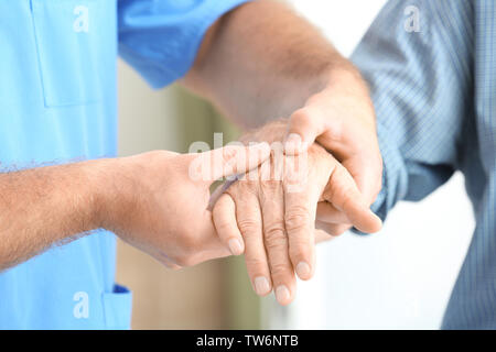 Fisioterapista dando senior man mano massaggi in clinica Foto Stock