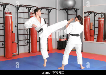 Giovane uomo e donna a praticare il karate nel dojo Foto Stock