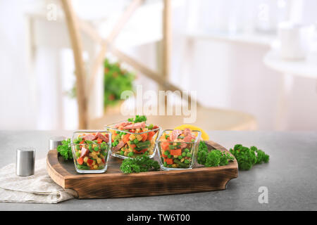 Insalata di verdure con salsiccia in ciotole in vetro sulla tavola di legno Foto Stock