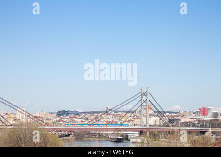 A Belgrado, in Serbia - Giugno 3, 2018: Panorama di Belgrado paesaggio visto dal fiume Sava, con un treno Beovoz passando su un ponte ferroviario di fronte. Belgra Foto Stock