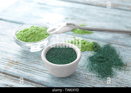 Spirulina e orzo polvere di erba in ciotole su sfondo di legno Foto Stock