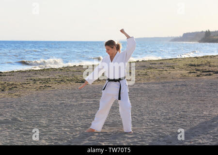 Giovane donna a praticare il karate all'aperto Foto Stock